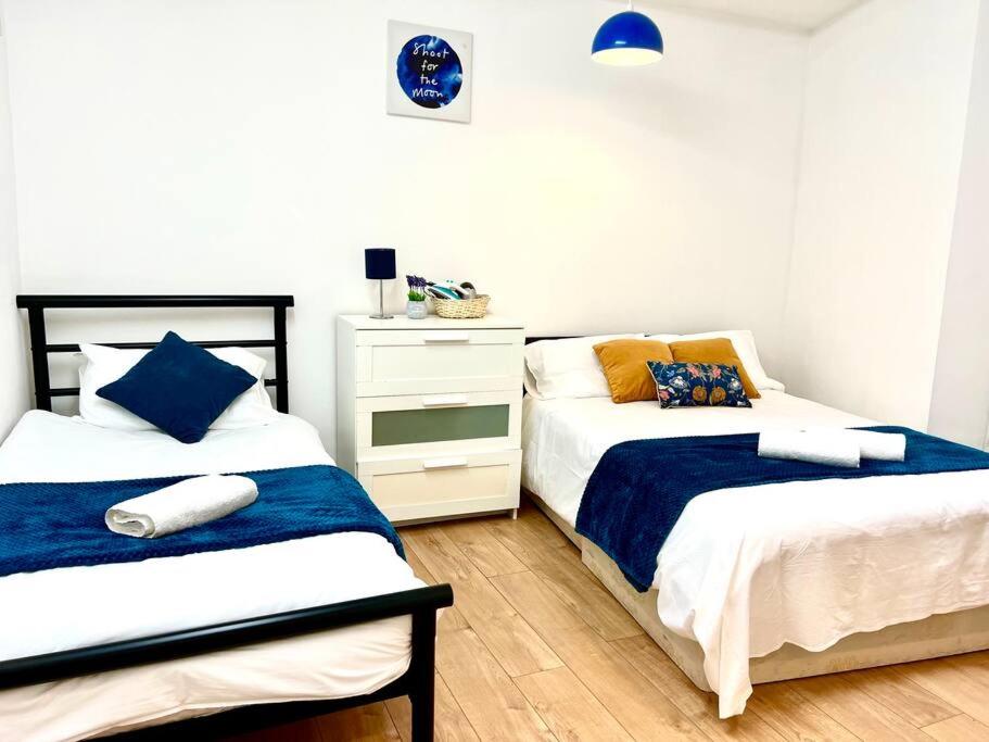 sypialnia z 2 łóżkami pojedynczymi i komodą w obiekcie Brilliant One Bedroom Flat in London w Londynie