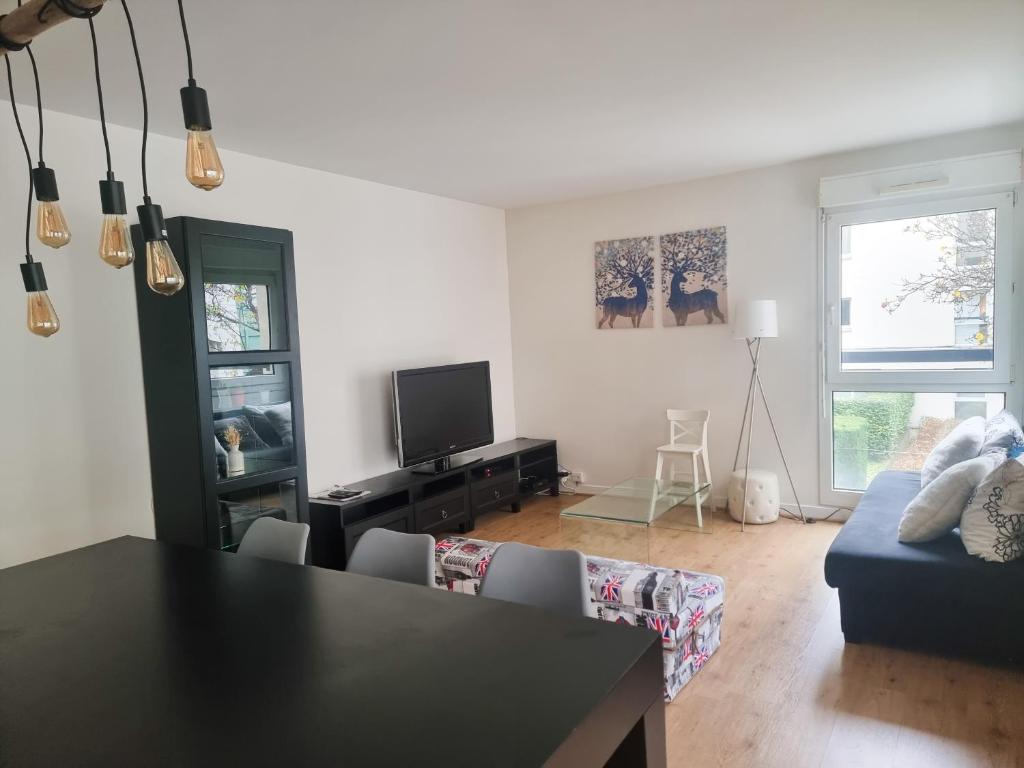 sala de estar con mesa y sofá azul en EXIGEHOME-Beautiful apartment, 2 bedrooms 70m2 15 min from Paris, en Rueil-Malmaison