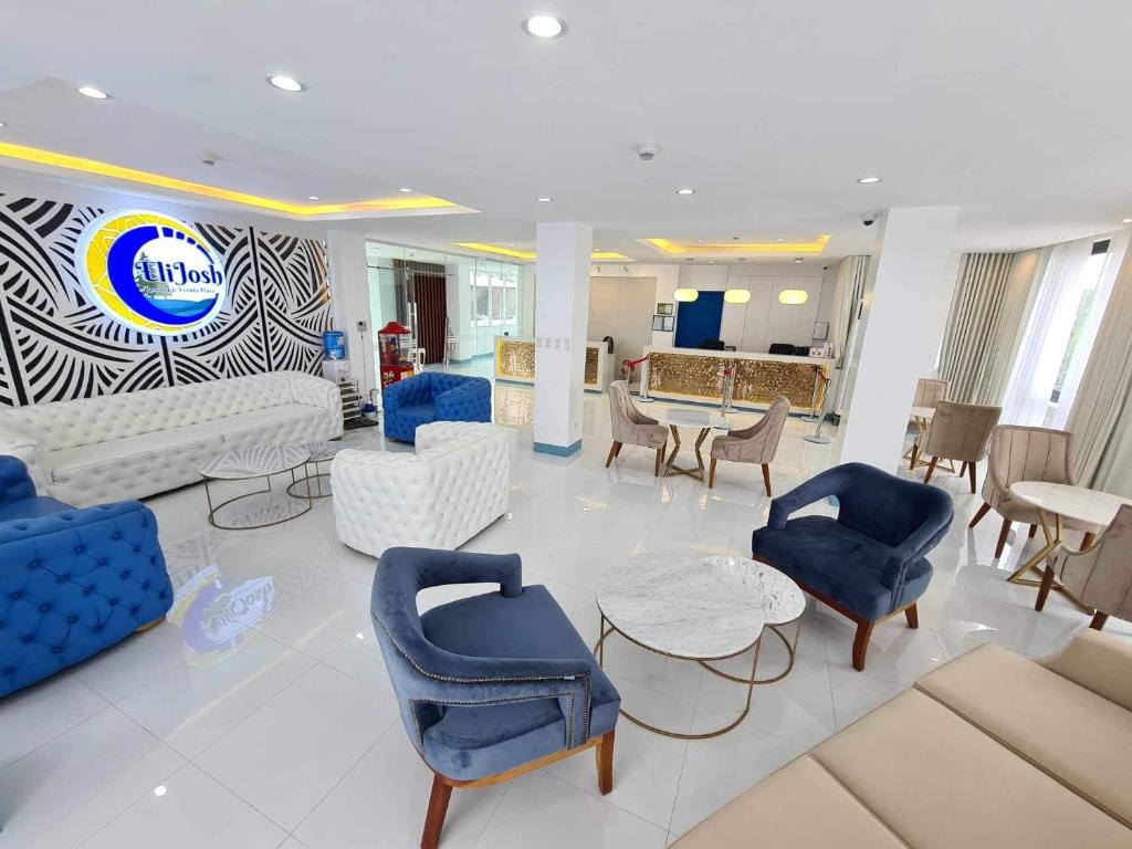 una sala de estar con mesas y sillas azules y blancas en EliJosh Resort and Events Place, en Silang