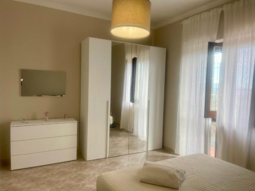ein Schlafzimmer mit einem Spiegel, einer Kommode und einem TV in der Unterkunft Villa Belvedere in Rocca Priora