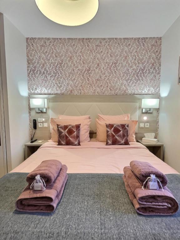 a bedroom with a large bed with purple blankets at &#39;&#39;Les Platanes&#39;&#39;de Miss.K Conciergerie in Gorrevod