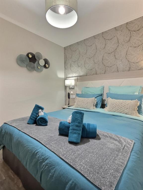 a large blue bed with blue pillows on it at &#39;&#39;Les Platanes&#39;&#39;de Miss.K Conciergerie in Gorrevod