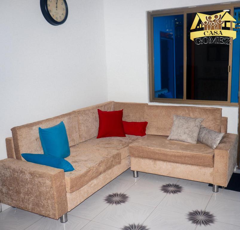 a living room with a brown couch with red and blue pillows at Casa Gomez Apto 2 in Leticia