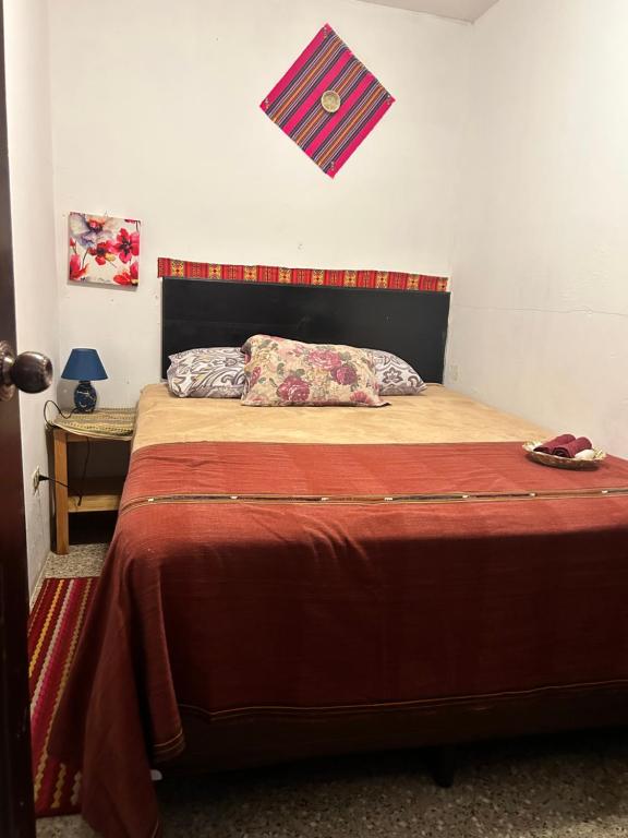 a bedroom with a large bed with a red blanket at Esperanza Hostel in Antigua Guatemala