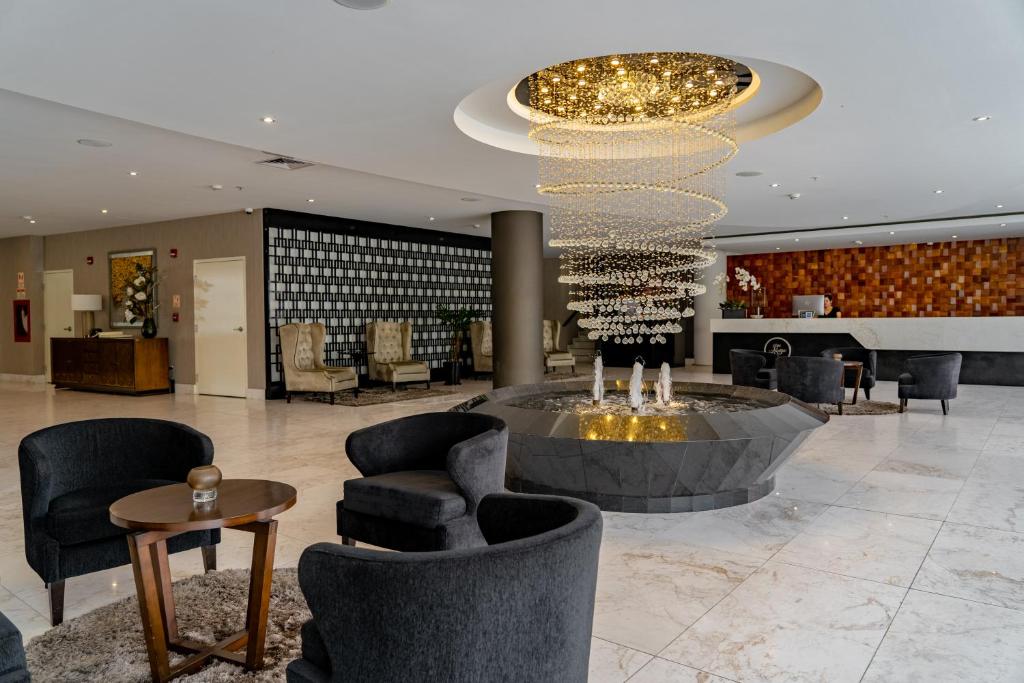 a lobby with chairs and a chandelier in a building at Jose Antonio Deluxe in Lima