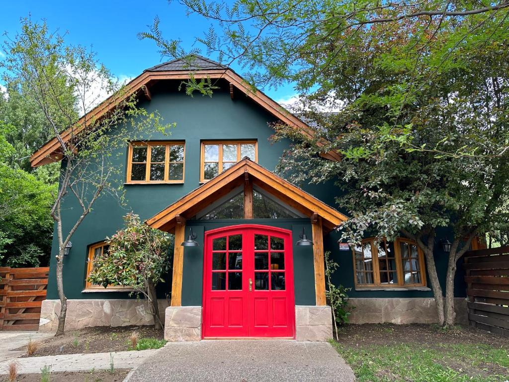 a small house with a red door at Warthon Hostel in San Martín de los Andes