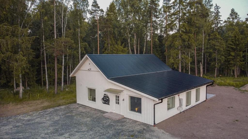 un petit hangar blanc avec un toit noir dans l'établissement Villa intill naturreservat, à Ryssby