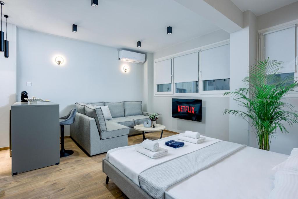 a white bedroom with a bed and a couch at Luxury Downtown Apartment Α2 in Thessaloniki