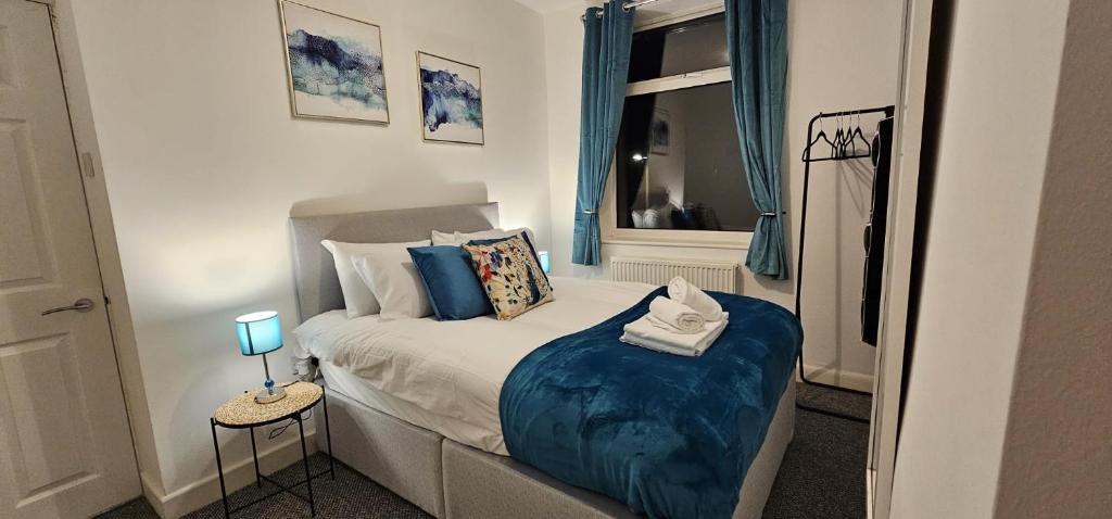 una camera da letto con un letto con cuscini blu e una finestra di 8 Suffolk street by Prestige Properties SA a Roose