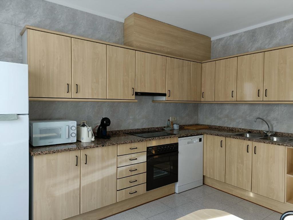 a kitchen with wooden cabinets and a white microwave at Muralla in Camprodon