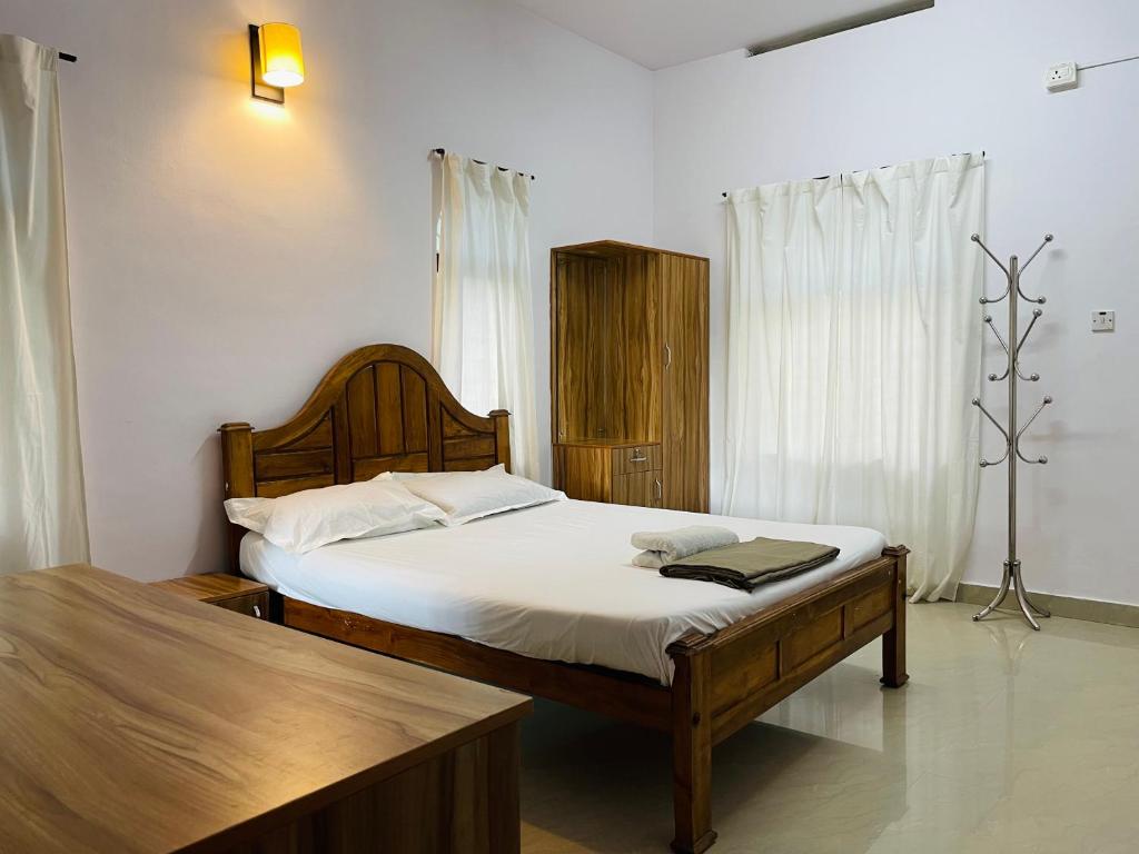 1 dormitorio con 1 cama grande con sábanas blancas en RiTAS en Varkala
