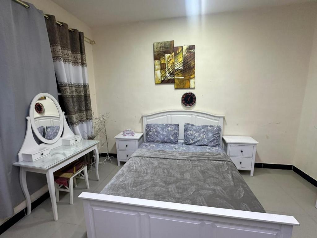 a bedroom with a bed and a vanity and a mirror at luule in Al Ain