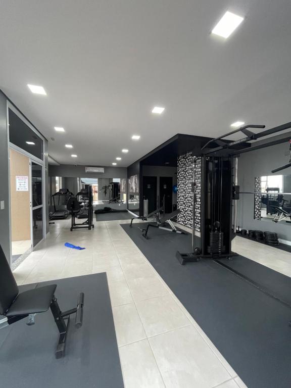 a gym with several treadmills and machines at Apartamento completo para veraneio in Torres