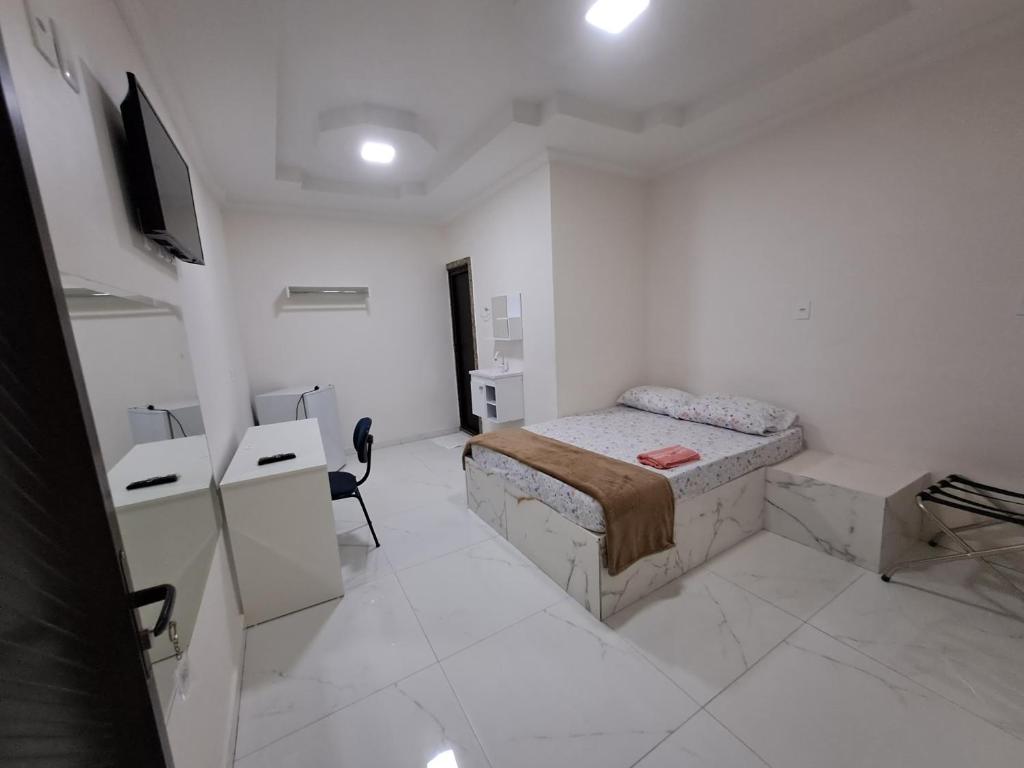 a white room with a bed and a tv in it at 3D Hotel in Manaus