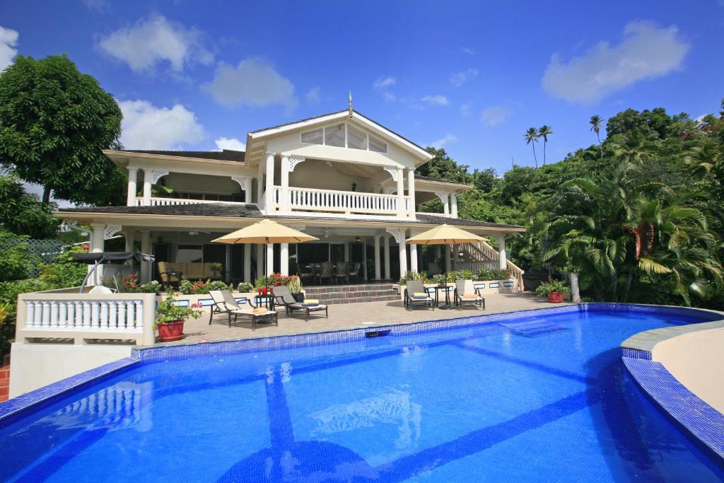 a house with a swimming pool in front of a house at Beautiful 5-Bedroom Villa Ashiana in Marigot Bay villa in Marigot Bay