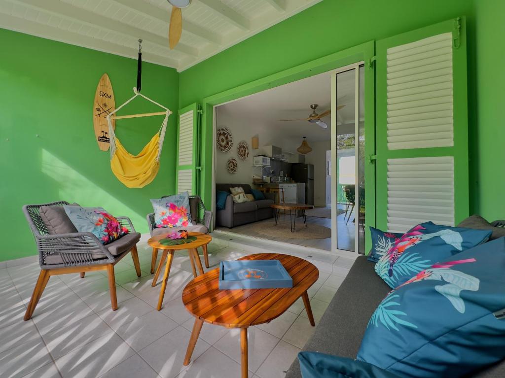 sala de estar con paredes verdes, sofá y mesa en My Happy Place in Orient Bay, en Orient Bay