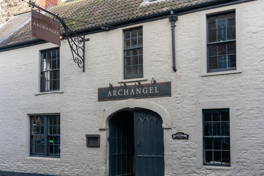 un edificio blanco con una señal sobre una puerta en The Archangel,Restaurant & Bar with Rooms, en Frome