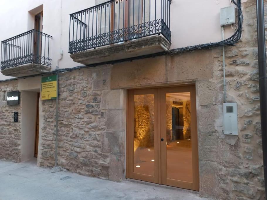 - un bâtiment avec une porte en verre et un balcon dans l'établissement Cal Vallverdú 2I, à Preixana