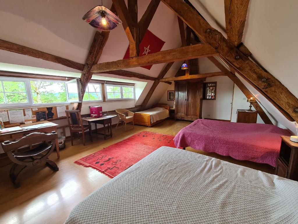 a attic room with two beds and a desk and a desk at Grande chambre calme avec vue, wifi et parking - Le Pêchereau - FR-1-591-559 in Le Pêchereau