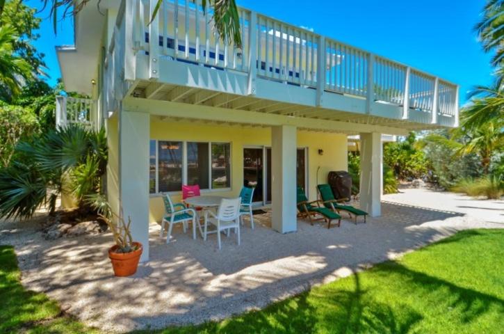 a house with a balcony and a table and chairs at Sunshine Place in Islamorada