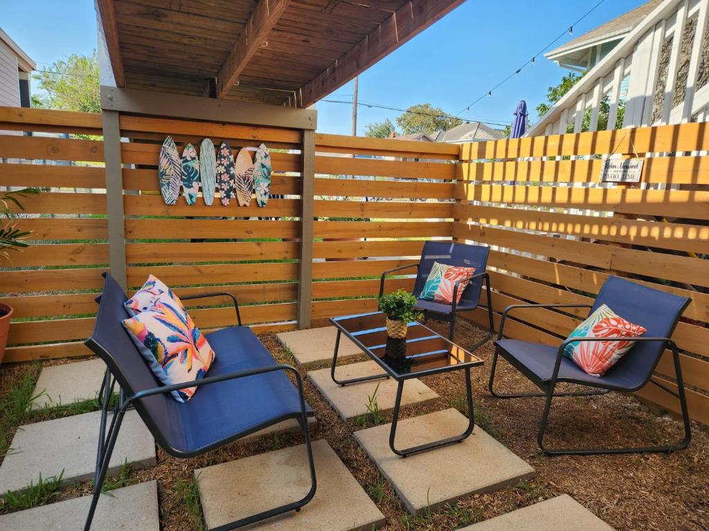 2 Stühle und ein Tisch auf einer Terrasse mit einem Zaun in der Unterkunft Relax in the Heart of Galveston in Galveston