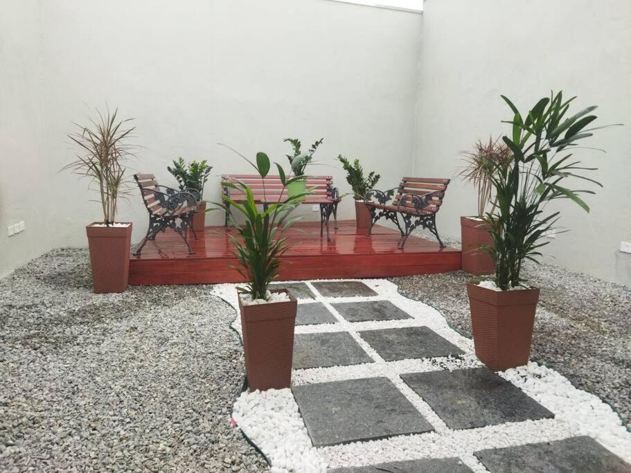 un groupe de chaises et de plantes dans une pièce dans l'établissement Kitnet 3 - próximo ao centro de Jacareí, à Jacareí