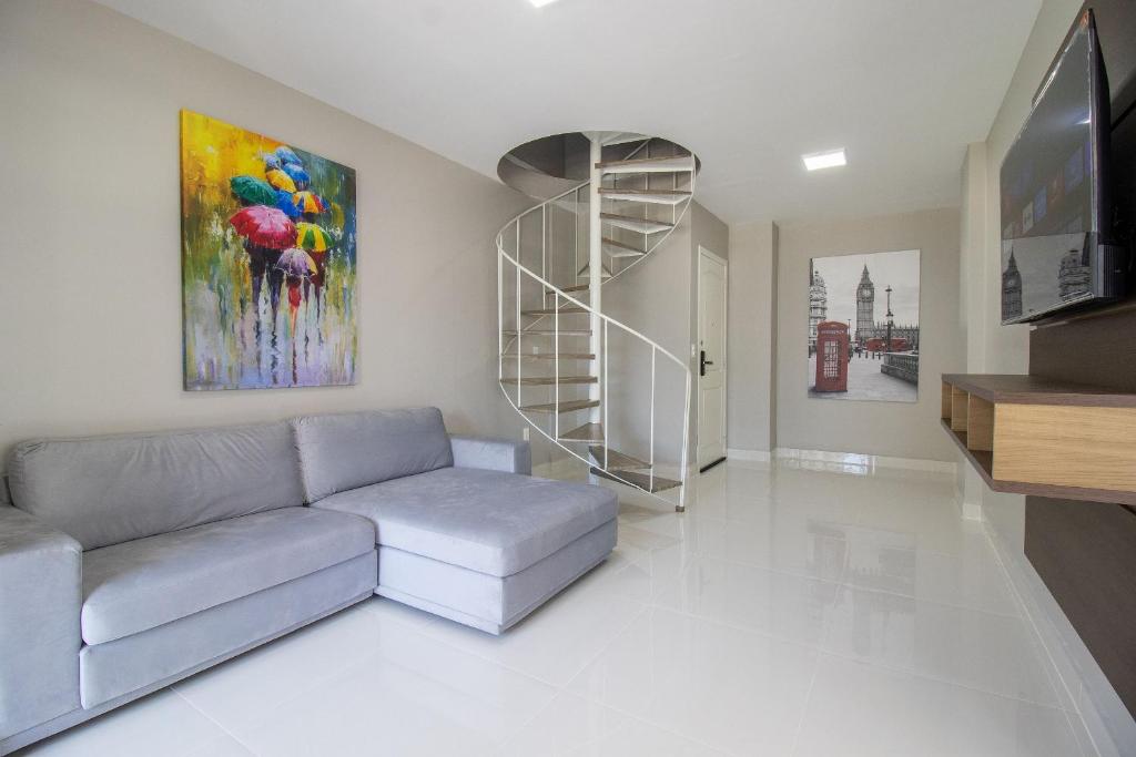 a living room with a couch and a painting at CB62 - Duplex, 4 Dorm Climatizados, Churrasqueira in Balneário Camboriú