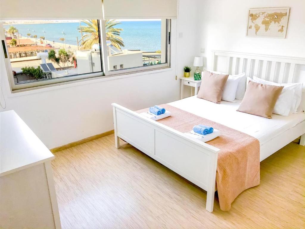 een slaapkamer met een bed en uitzicht op het strand bij Seaview Apartment (Excellent Location) in Larnaka