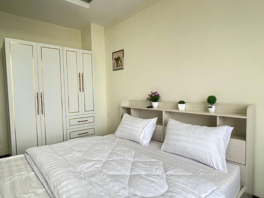 a bedroom with a large white bed with two pillows at Orkide Condo By 365Home in Phnom Penh