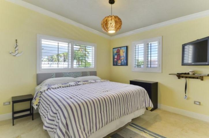 a bedroom with a bed and a tv and windows at West Plaza Del Lago in Islamorada