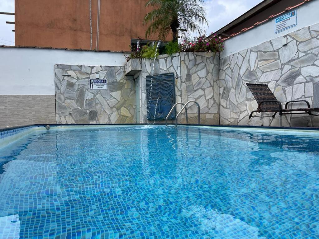 a large blue swimming pool next to a building at Chalés Camburi in São Sebastião