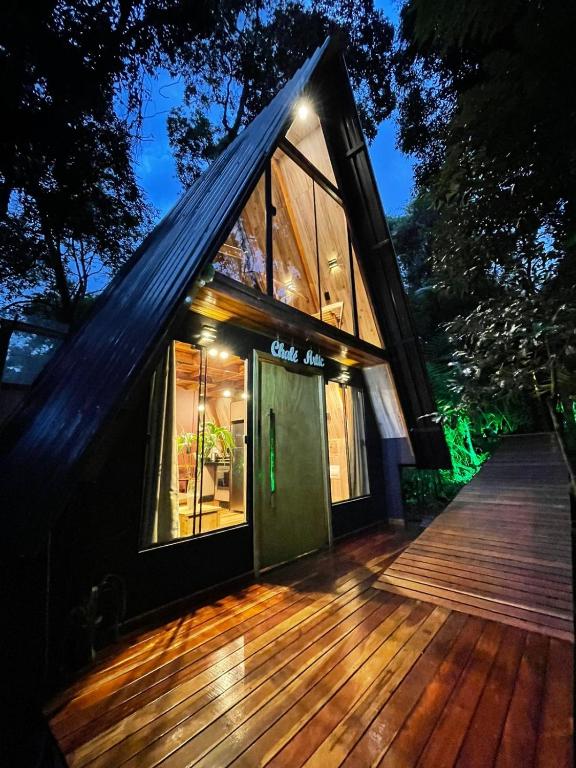 una casa con una porta verde su una terrazza di legno di Deck1920 by Estadias Incríveis a Cascavel