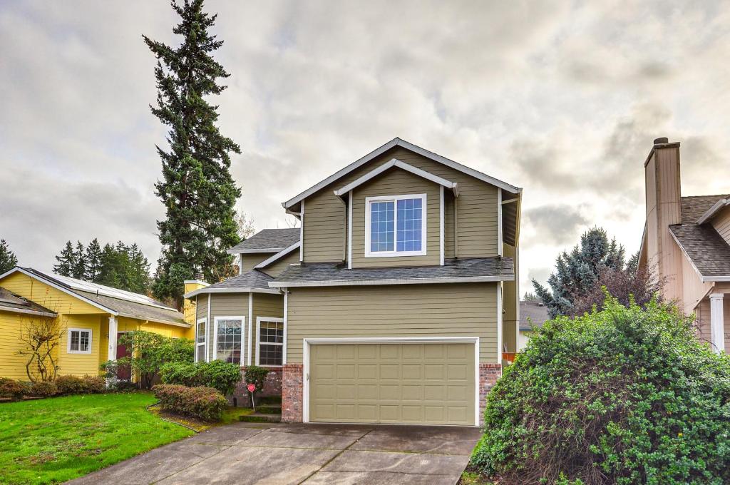 a house with a garage in a yard at Charming Beaverton Retreat about 12 Mi to Downtown! in Beaverton