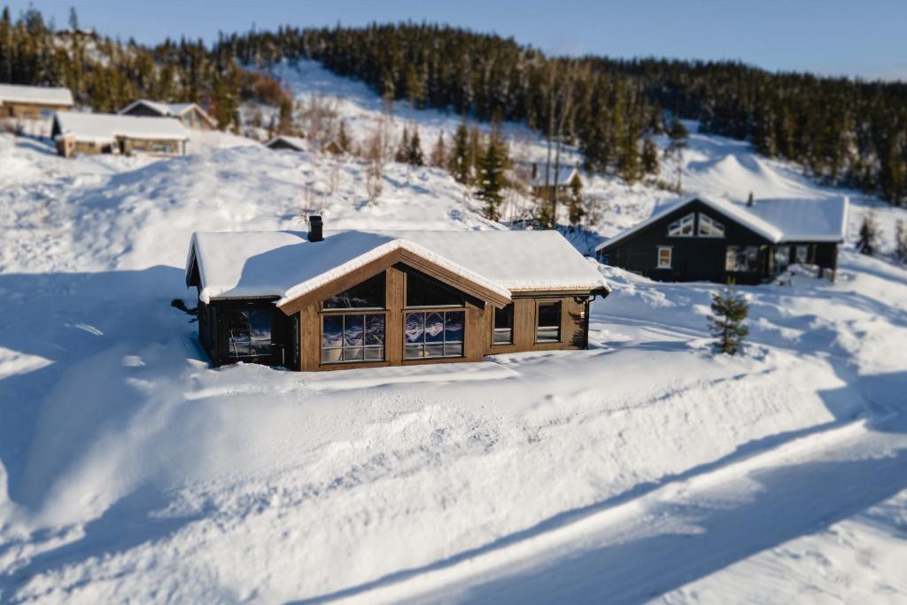 Cabaña de madera con nieve en el suelo en Ski inn-ski ut hytte i Aurdal - helt ny, en Aurdal