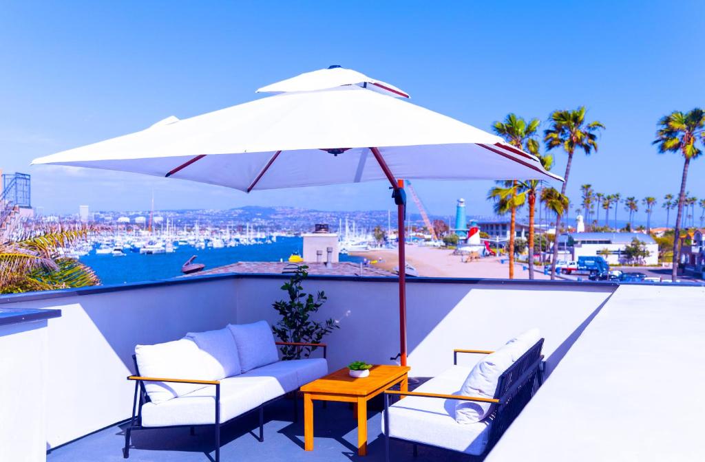 a patio with a table and a white umbrella at The Harbor Lookout in Newport Beach