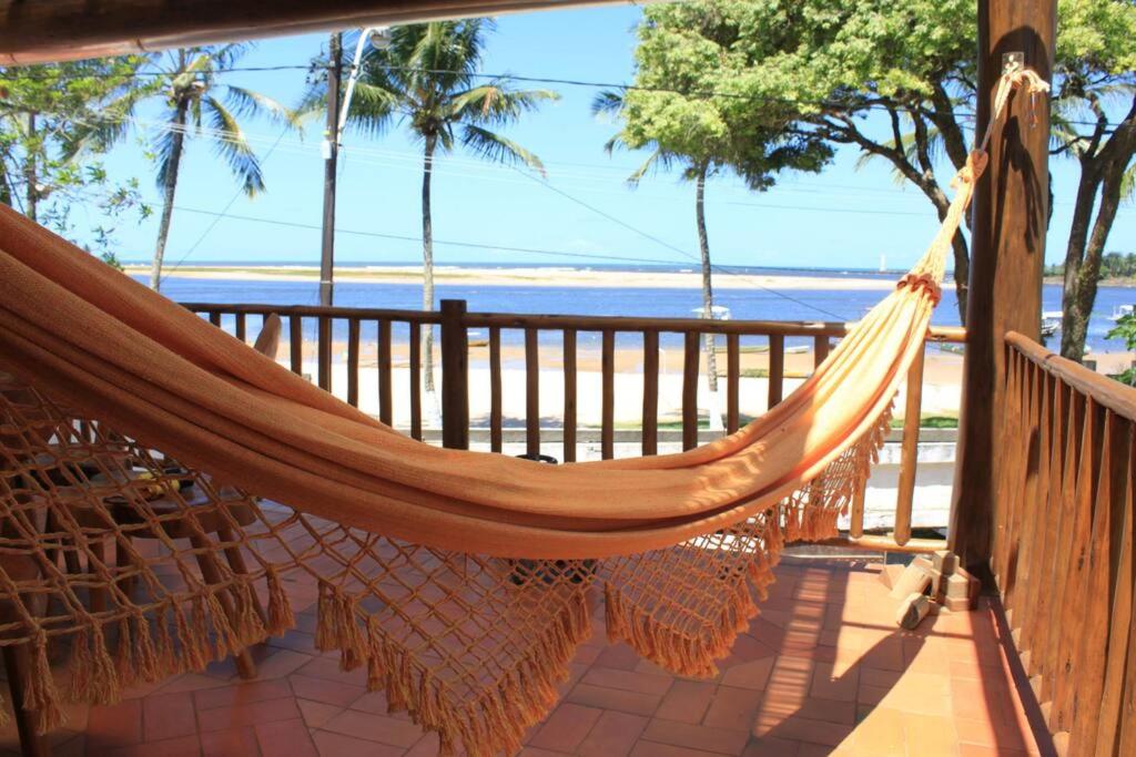 a hammock on a porch with a view of the beach at Beautiful house on the Orla in Itacaré