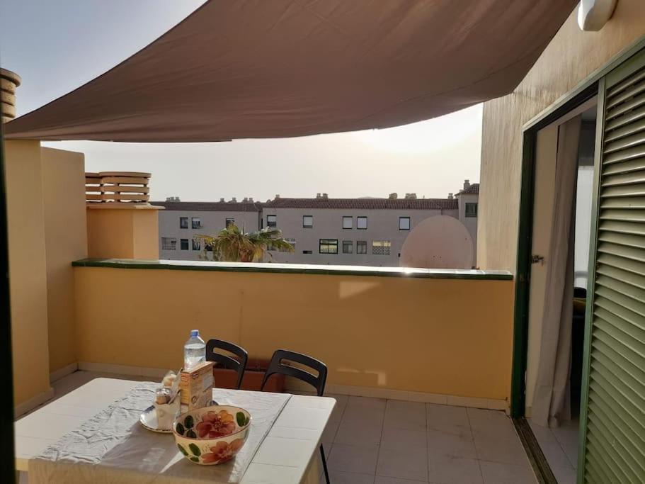 una mesa con un bol de fruta en el balcón en amarilla terrace en Arona