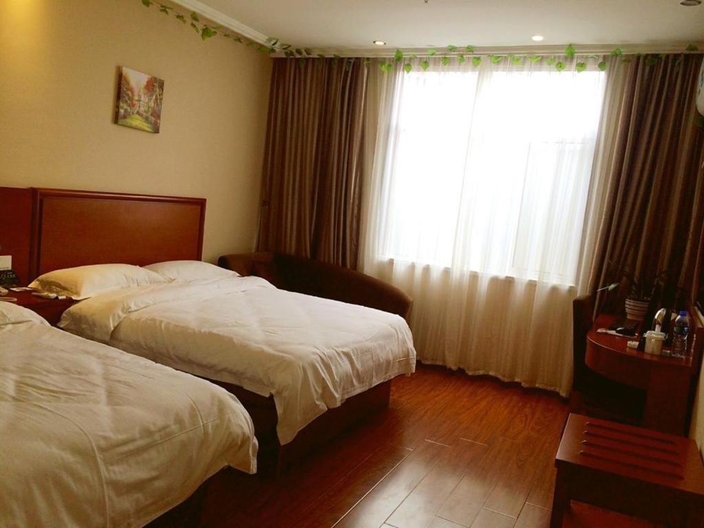 Un pat sau paturi într-o cameră la GreenTree Inn Fuyang Shopping Mall