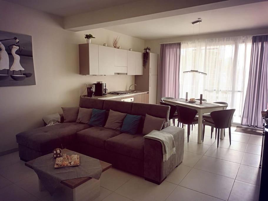 ein Wohnzimmer mit einem Sofa und einem Tisch sowie eine Küche in der Unterkunft OceanDream Beach House Apartment in Sal Rei
