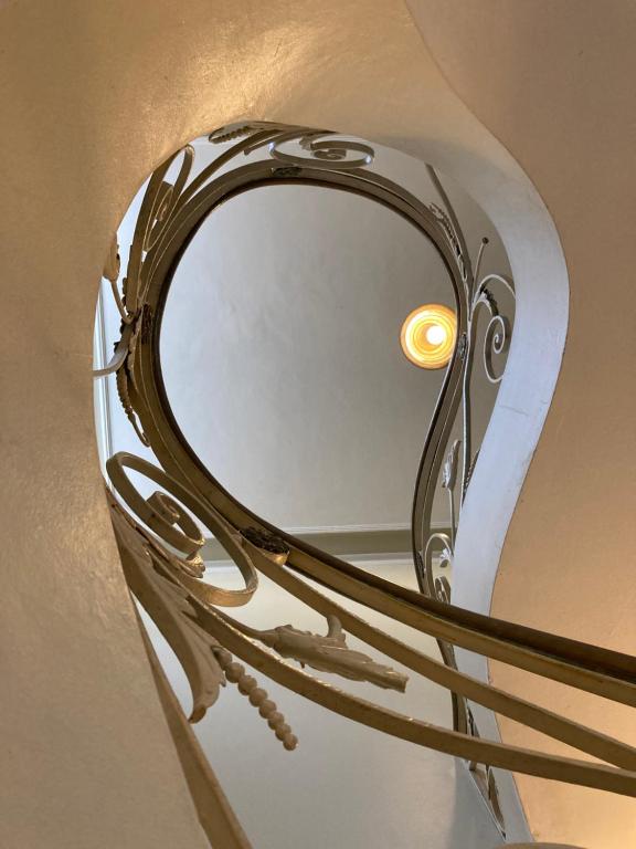 a chrome mirror with a light on a wall at Chez Zany Boutique Hostel - Copacabana in Rio de Janeiro