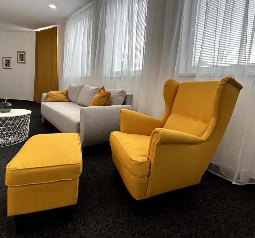 a living room with two chairs and a couch at BREZA HOUSE apartments in Zlín