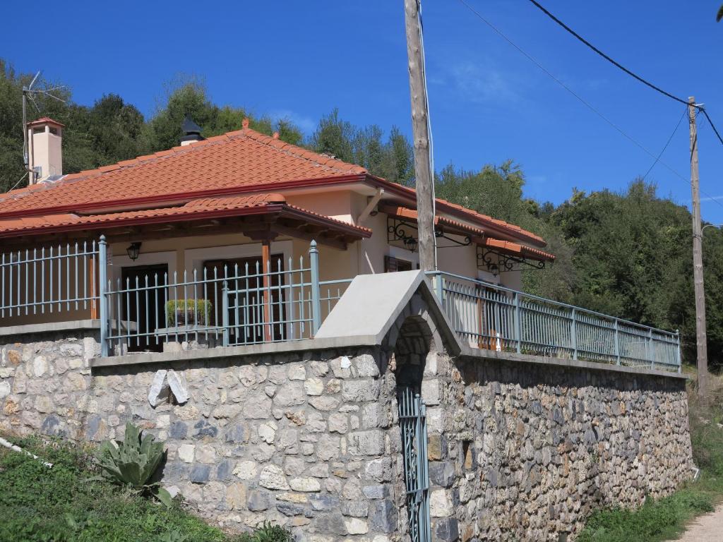 uma casa com uma parede de pedra e uma varanda em Methydrion Country House em Vytina