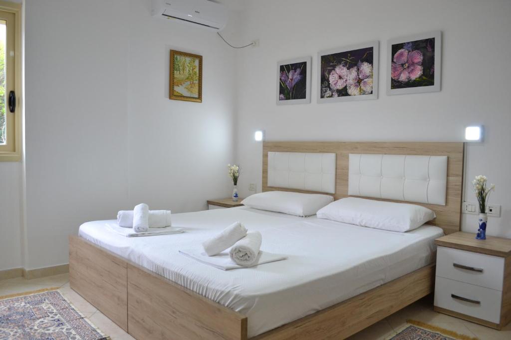a bedroom with a large white bed with towels on it at Flowers & Green 2 Bedrooms Apartment & Private garage in Vlorë