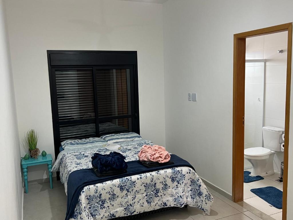 Schlafzimmer mit einem Bett mit einem schwarzen Kopfteil in der Unterkunft Vista Privilegiada 5 minutos da Basílica in Aparecida