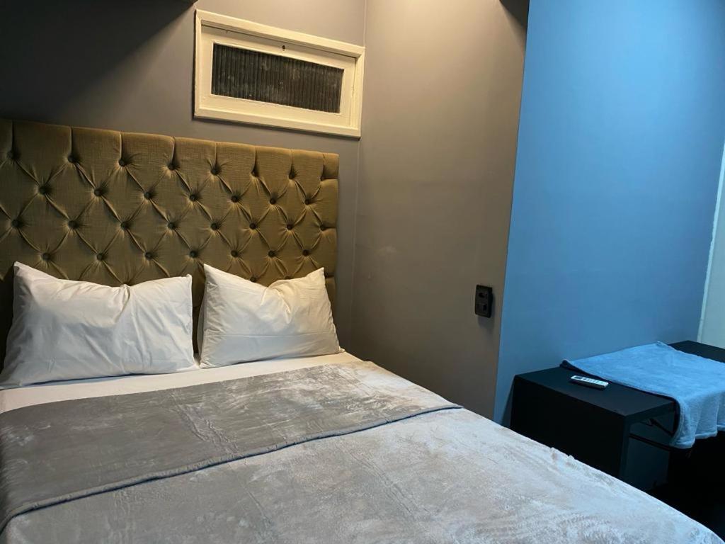 una camera da letto con letto con testiera e luce blu di Casa em Piranhas AL - Alto Padrão a Piranhas
