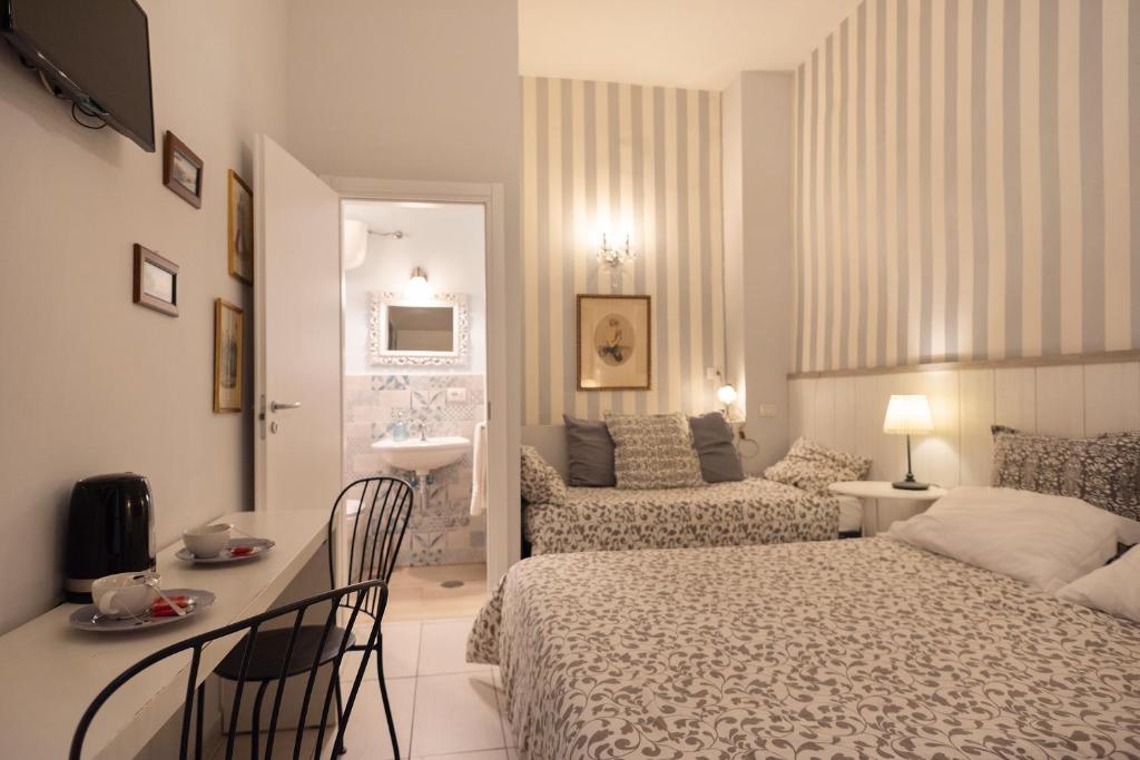 una camera da letto con un letto, un tavolo e delle sedie di B&B Dei Decumani a Napoli