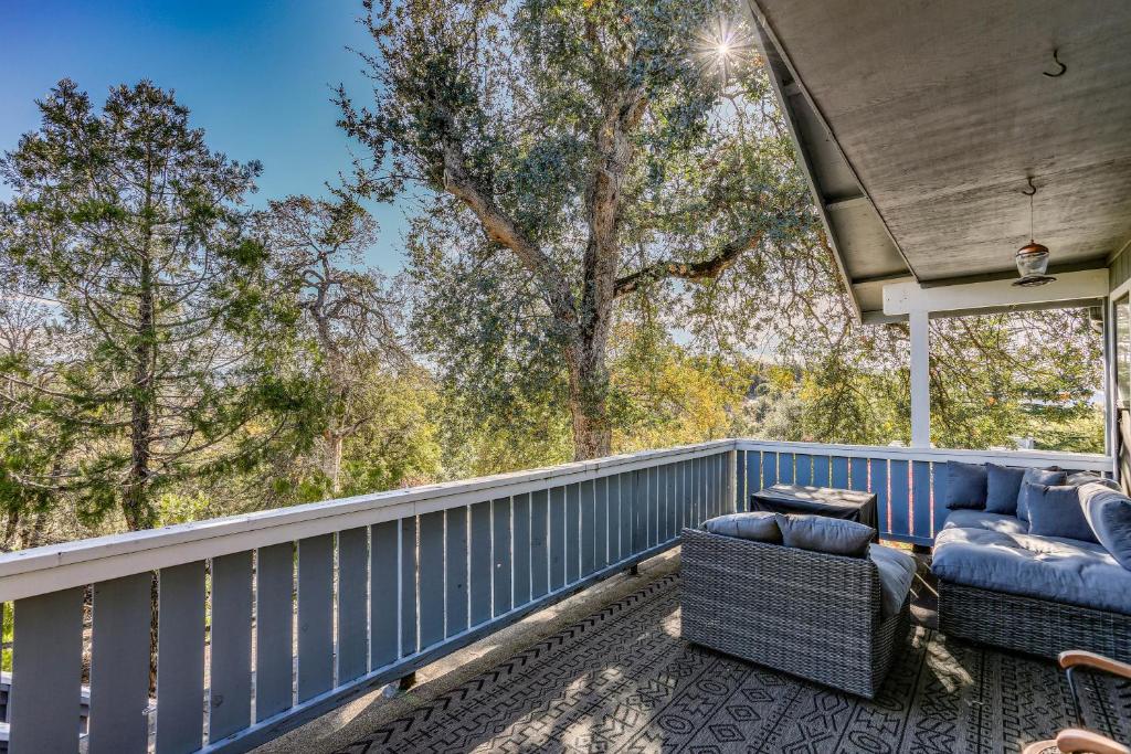 een balkon met blauwe meubels en bomen op de achtergrond bij Cozy Studio with Well-Being Retreat Near Yosemite! in Ahwahnee