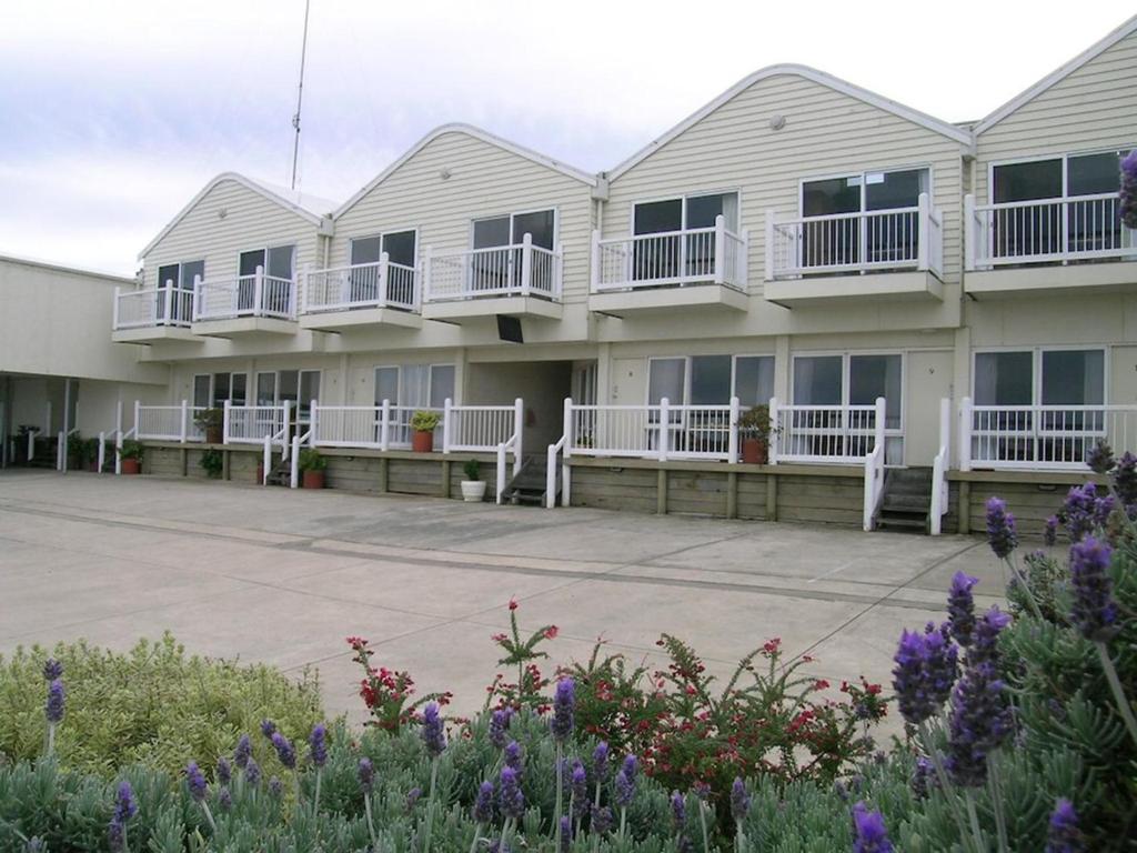 een rij huizen met balkons en bloemen bij A Great Ocean View Motel in Apollo Bay
