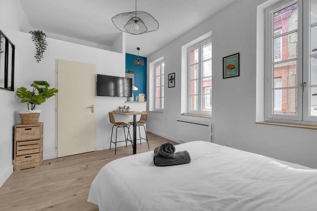 une chambre blanche avec un lit et une cuisine dans l'établissement Charme Toulousain - Hyper centre - Proche Métro, à Toulouse