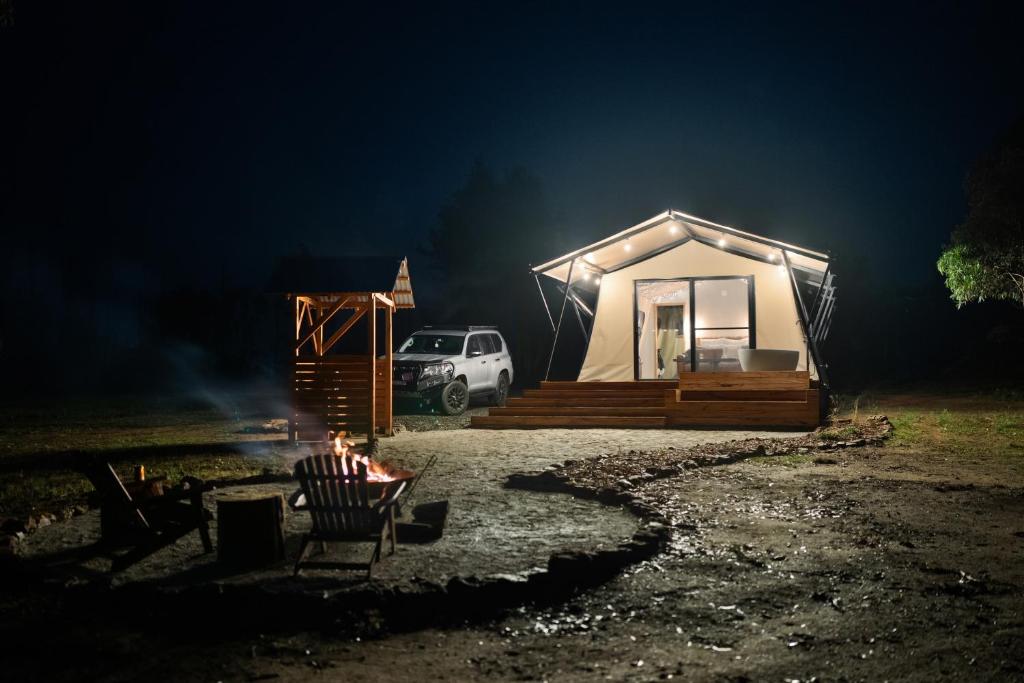 una persona sentada en una silla frente a una tienda en Akuna Estate - Luxury Glamping Experience en Excelsior